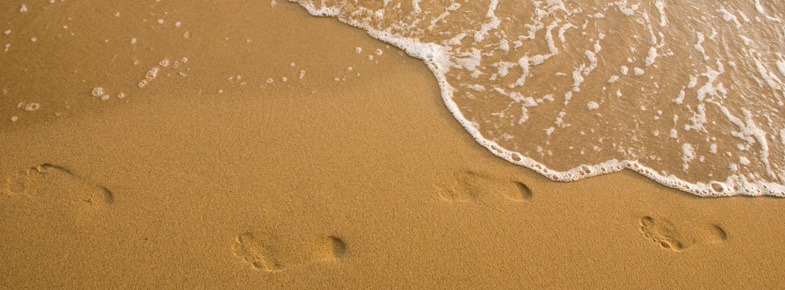 Fußspuren im nassen Sand am Strand