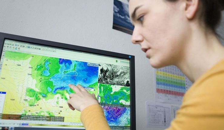 Eine junge Frau sitzt am Monitor und wertet eine Wetterkarte aus. Foto Franziska Frenzel