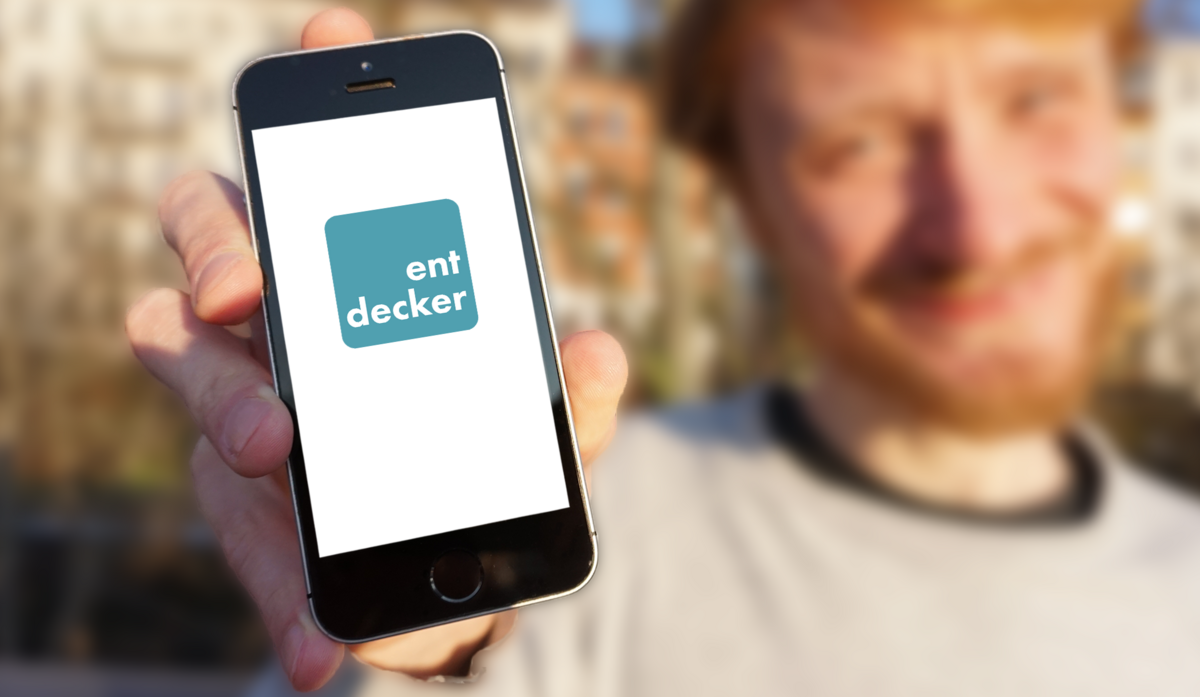 Ein junger Mann hälte ein Smartphone mit der Aufschrift Entdecker-App in die Kamera. Foto: Universität Leipzig