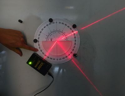 roter Laserstrahl, der aus Glas in Luft strahlt, mit Brechung und Reflexion am Übergangspunkt, Foto: Peter Rieger und Kilian Peisker