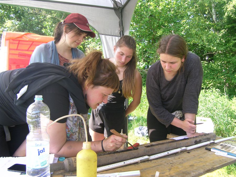zur Vergrößerungsansicht des Bildes: Studierende werden im Feldpraktikum angeleitet einen Bohrkern anzusprechen, Foto: C. Zielhofer
