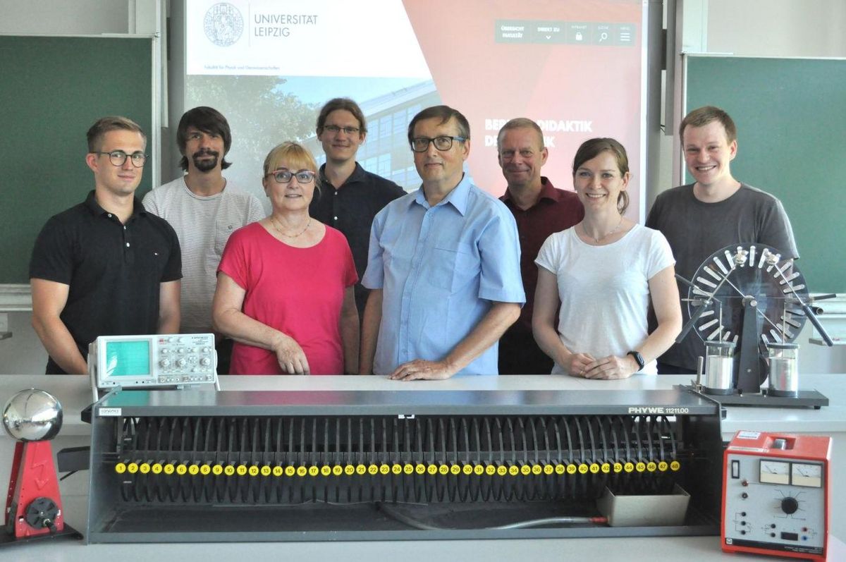 Gruppenfoto des Teams des Bereichs Didaktik der Physik mit Experimentiergerätschaften im Vordergrund, Foto: Grit Müller, Universität Leipzig