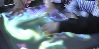 Schülerinnen und Schüler beim Experimentieren mit einem berührungssensitiven optischen Tisch bei der Langen Nacht der Wissenschaften